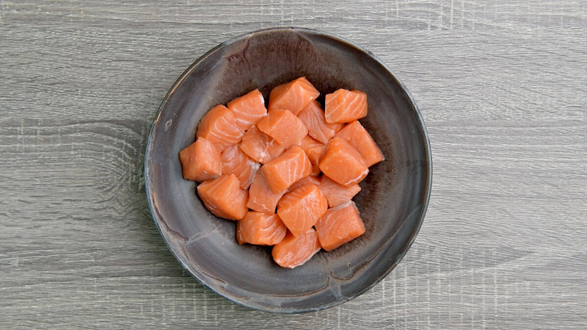 Raw salmon cubes in a bowl.