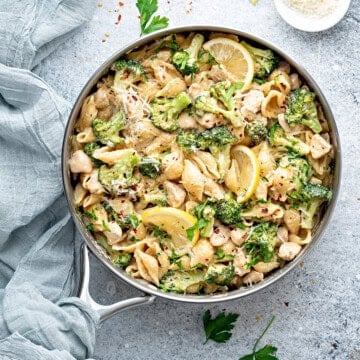 Deep skillet with cooked chicken broccoli pasta.
