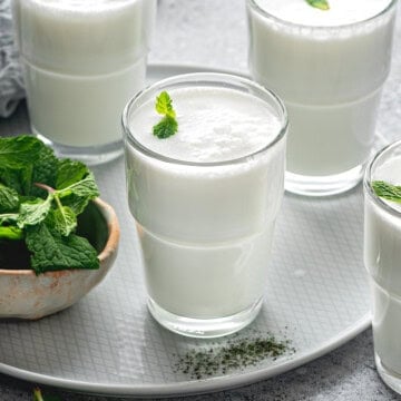 3 glasses of frothy ayran drink with fresh mint.