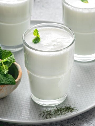 3 glasses of frothy ayran drink with fresh mint.