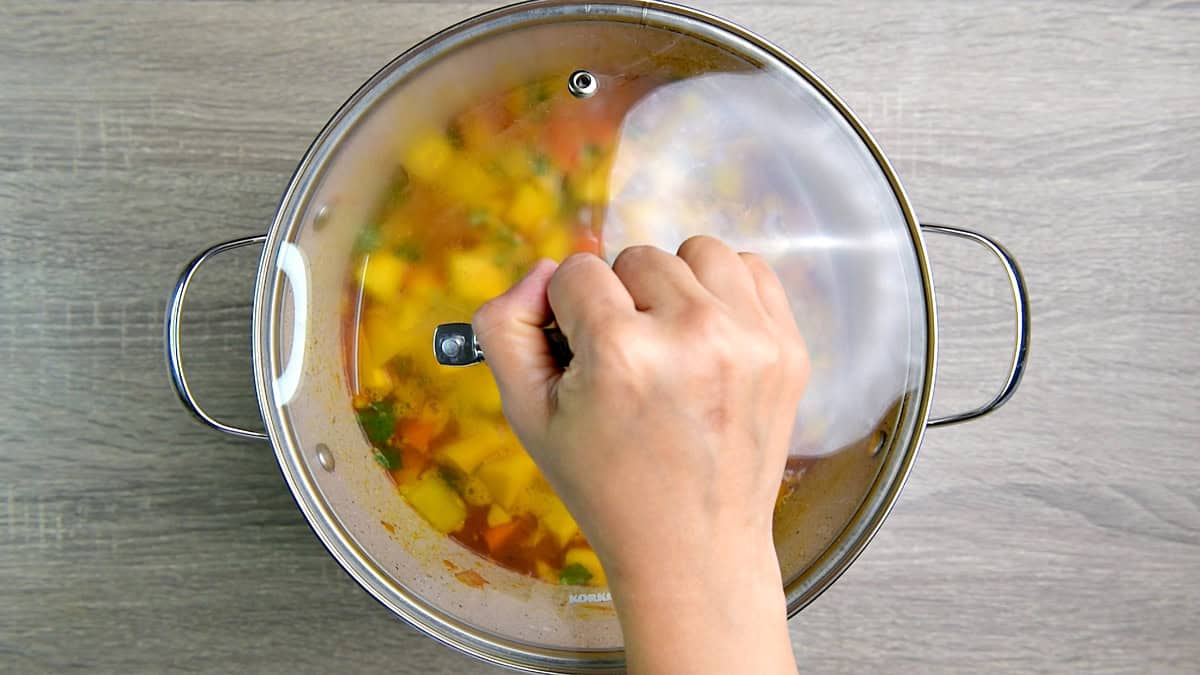 A hand placing the top on the pot. 