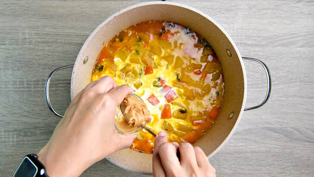 Adding the coconut milk and peanut butter to the pot. 