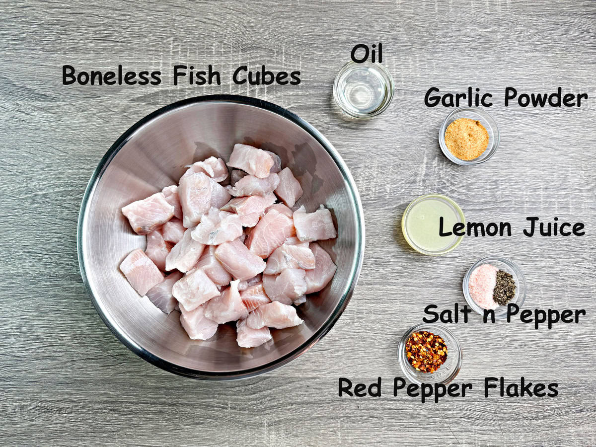 Boneless fish cubes, oil, garlic powder, lemon juice, salt and pepper, red pepper flakes in individual bowls.