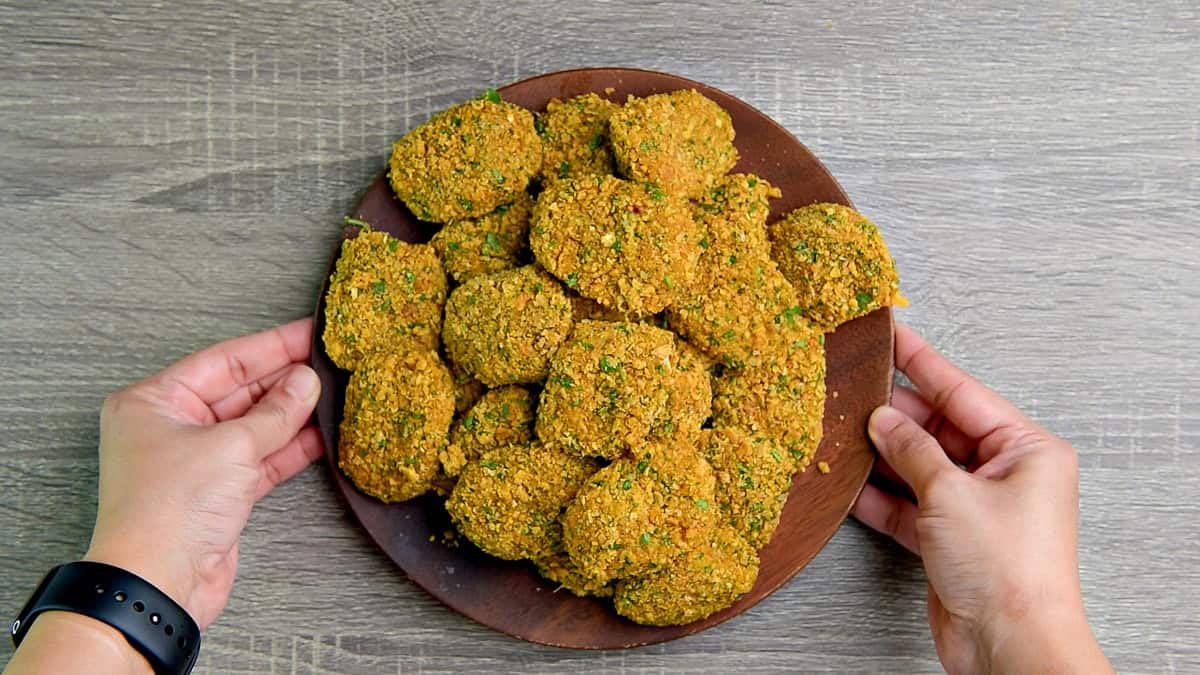 The fish nuggets coated with the cornflake herb mixture on a plate.